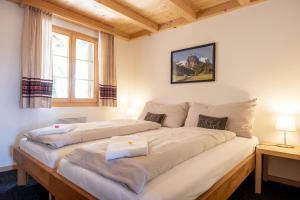 a large bed in a room with two beds at Tälli Hütte in Gadmen