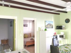 a living room with a table and a refrigerator at Appartement de 2 chambres avec vue sur la mer terrasse amenagee et wifi a Bouillante a 4 km de la plage in Bouillante
