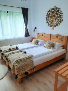 a bedroom with two beds and a tree on the wall at Casa Phoenix in Băişoara
