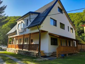 uma grande casa branca com um telhado preto em Casa Phoenix em Baisoara