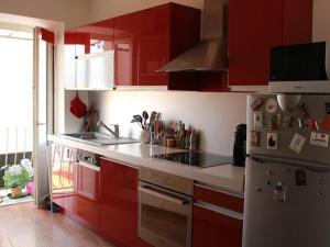 a kitchen with red cabinets and a stove at Appartement Ajaccio, 1 pièce, 2 personnes - FR-1-61-473 in Ajaccio