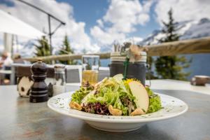 um prato de comida numa mesa com uma salada em Tälli Hütte em Gadmen