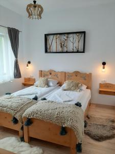 sypialnia z 2 łóżkami i lustrem na ścianie w obiekcie Casa Phoenix w mieście Băişoara