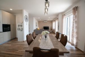 a dining room with a long wooden table and chairs at APARTMAN RUBINIĆ in Ičići