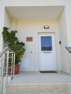 eine weiße Tür in einem Gebäude mit Fenster in der Unterkunft Serenity apartment Mochlos in Mochlos