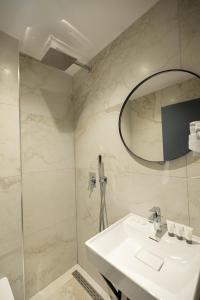 uma casa de banho com um lavatório e um espelho em Aglon Twin's Hotel em Vlorë