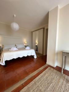 a bedroom with a bed with white sheets and a rug at Agave Marina in Marciana Marina