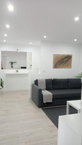 een woonkamer met een zwarte bank en een witte muur bij Apartamento a estrenar a 300 m de la playa de San Lorenzo en Gijón in Gijón