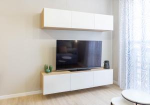 ein Wohnzimmer mit einem TV in einem weißen Unterhaltungszentrum in der Unterkunft Luxury Apartment Dos Aceras in Málaga