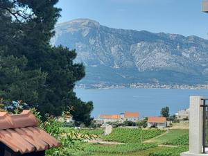 a view of a lake and mountains from a bench at VILLA Apartments Mate Cebalo in Lumbarda