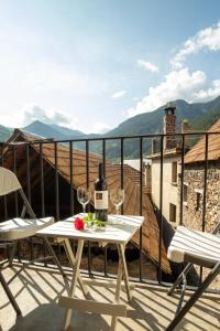 a table with wine glasses on a balcony with a view at Estudio Calle Alta in Plan