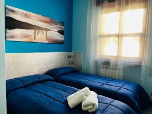 a blue room with two beds and a towel at [Chi Ama il Mare] Appartamento in Latina