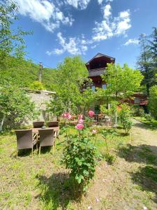 ein Haus mit einem Tisch, Stühlen und Blumen in der Unterkunft MOUNTAIN HOUSE in Trabzon