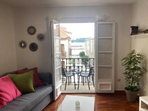 a living room with a couch and a balcony at HyP- A Casa do Correo - O Balcón in Pontevedra