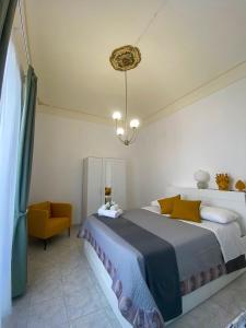a bedroom with a large bed and a chair at Casa Noto in Noto