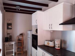 a kitchen with white cabinets and a black counter top at Appartement de 2 chambres avec vue sur la mer terrasse amenagee et wifi a Bouillante a 4 km de la plage in Bouillante