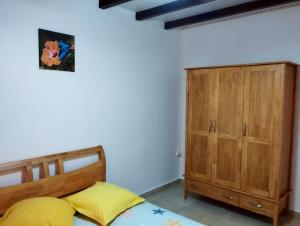 a bedroom with a bed and a wooden cabinet at Appartement de 2 chambres avec vue sur la mer terrasse amenagee et wifi a Bouillante a 4 km de la plage in Bouillante