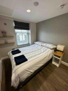 ein Schlafzimmer mit großem Bett und Fenster in der Unterkunft LUNA LUX Apartment in Portrush