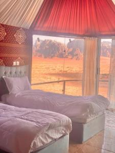 Desert guide camp في وادي رم: غرفة نوم بسريرين وإطلالة على صحراء