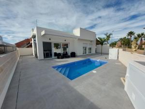 a villa with a swimming pool in front of a house at Villa María in Alicante
