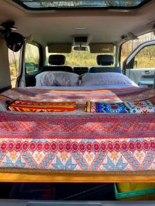 a bed in the back of a van with a blanket at Campervan/Maui hosted by Go Camp Maui in Kihei