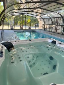 - un bain à remous dans un bâtiment avec une piscine dans l'établissement Le Domaine du Lavoir, à Villemoiron-en-Othe