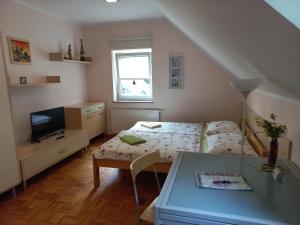 a small bedroom with a bed and a table at Oriana Studios in Bled