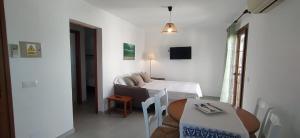 Mały, biały pokój z łóżkiem i stołem w obiekcie Apartamentos Villa Primera w mieście Cala Figuera