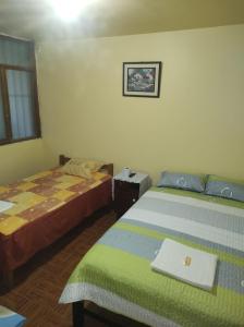 a bedroom with two beds and a laptop on the bed at CasaBlanca in Nazca