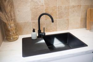 a black sink in a kitchen with a counter at Capitão Ribeiro Surf House in Costa da Caparica