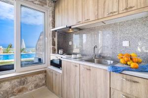 a kitchen with a sink and a large window at Gkountis Apartments in Tsoukalades