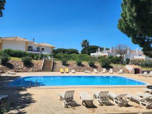 a group of lounge chairs and a swimming pool at Maison de charme, Olhos de Água, Albufeira in Roja- Pé