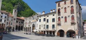 un grupo de edificios en una calle con una montaña en Flaminio's Suite Vittorio Veneto, en Vittorio Veneto