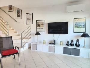 a living room with a flat screen tv on a wall at Maison de charme, Olhos de Água, Albufeira in Roja- Pé