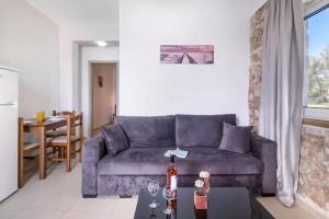 - un salon avec un canapé bleu et une table dans l'établissement Gkountis Apartments, à Tsoukaladhes