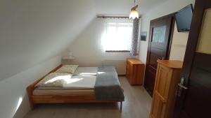 niewielka sypialnia z łóżkiem i oknem w obiekcie Noclegi u Bartka w Sromowcach Niżnych