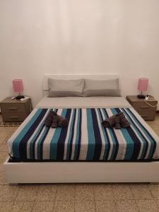 ein Bett mit zwei Nachttischen und zwei Schuhen drauf in der Unterkunft Casa del Ciancio in Palermo