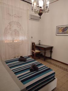 Zimmer mit einem Bett, einem Tisch und einem Kronleuchter in der Unterkunft Casa del Ciancio in Palermo