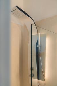 a glass shower door with a lamp on the wall at Esmeralda Apartments in Apollonia