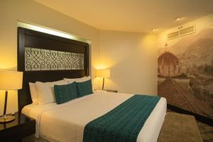 a hotel room with a large bed with a green blanket at Casa del Alma Hotel Boutique & Spa in San Cristóbal de Las Casas