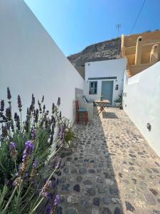 フィラにあるPoli Cave House Santoriniの建物の前にテーブルと花が飾られたパティオ