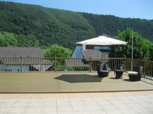 a patio with an umbrella and a table and chairs at Julia's Mosel Villa Appartement JULIA in Traben-Trarbach