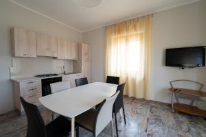 a kitchen with a white table and chairs in a room at Sunrise Apartment in Guardavalle