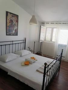 a large bed in a room with white walls and windows at Apartman Lucija in Murter