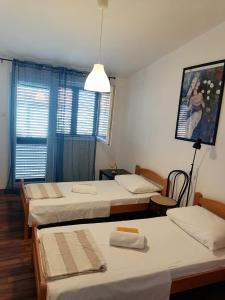a room with three beds and a pendant light at Apartman Lucija in Murter