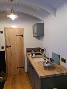 uma cozinha com um lavatório e uma bancada de madeira em Milberry Green Meadows em Warlingham