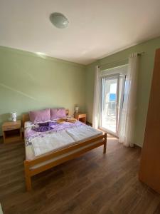 a bedroom with a bed and a large window at Apartments Klikovac Liman II in Ulcinj