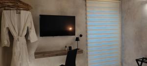a living room with a tv on a wall at ClockWise Earthy Vibe House in Apano Chora in Ano Syros