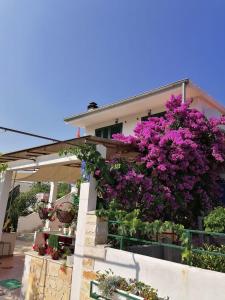 a house with purple flowers on the side of it at Apartman Lucija in Murter