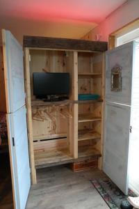 Habitación con TV en un armario de madera. en Tiny home Texel, en Den Burg